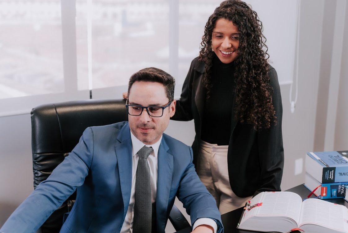 Advogado Michael Santos e Talita, da equipe do escritório, analisando um caso em Santa Bárbara/MG